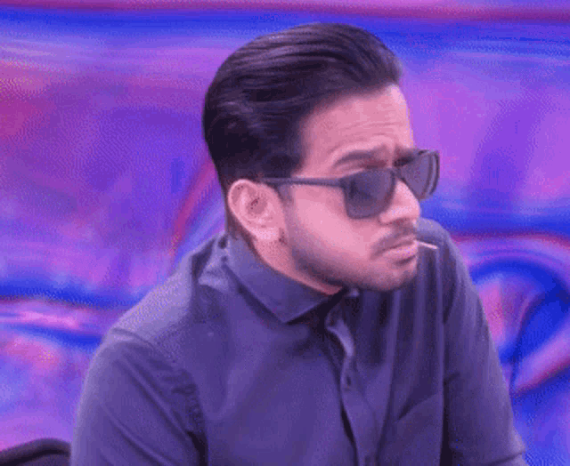 a blurry picture of a man 's face against a purple and blue background