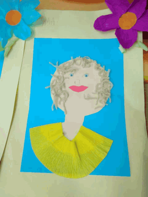 a child 's drawing of a woman with a yellow skirt is on a piece of paper