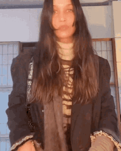 a woman wearing a black jacket and a sweater that says ' i 'm sorry ' on it