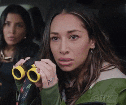a woman in a green jacket is looking through binoculars with a ctv logo in the background