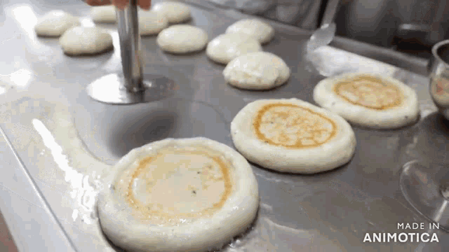 a bunch of pancakes are being cooked on a stove and the words made in animotica are visible