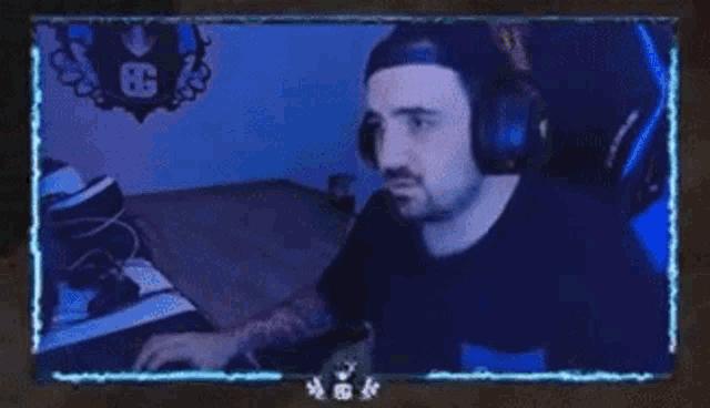 a man wearing headphones is sitting in front of a computer monitor .