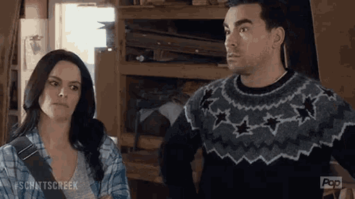 a man and woman are standing next to each other in a room .