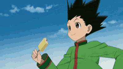 a boy in a green shirt is holding a yellow popsicle