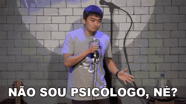 a man stands in front of a microphone with the words " não sou psicologo ne " below him