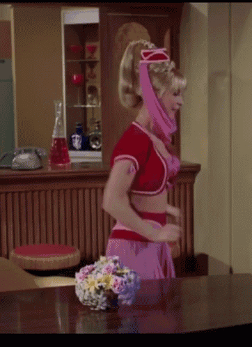 a woman in a pink costume is standing in front of a table