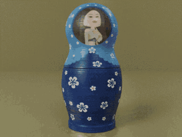 a blue green and orange russian nesting doll with a woman in the middle