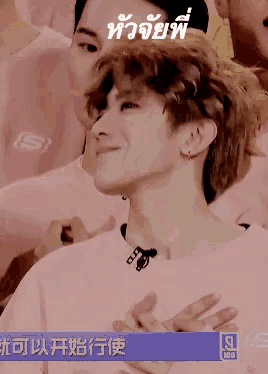 a man in a pink shirt is smiling in front of a sign that says seo
