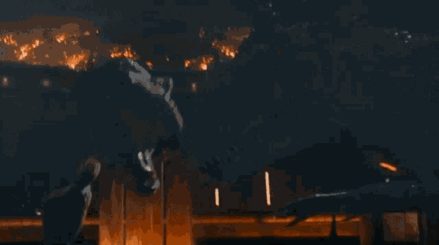 a t-rex is standing in front of a building on fire