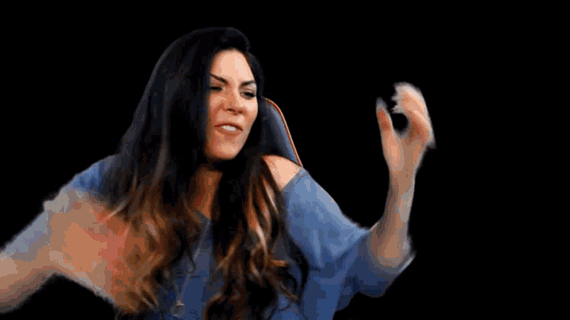 a woman with long hair is sitting in a chair with her hands outstretched