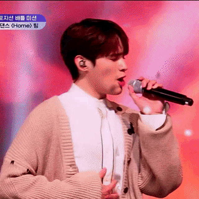 a man singing into a microphone with a foreign language on the bottom left
