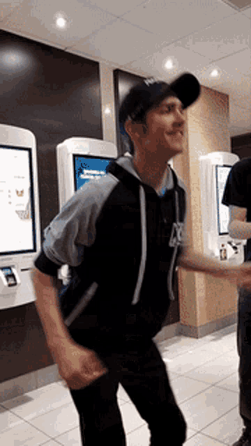 a man wearing a mcdonalds hat is dancing in a restaurant