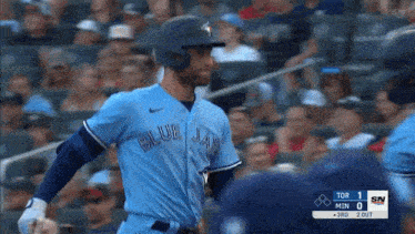 a man in a blue jays jersey is standing on the field