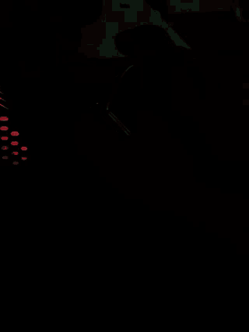 a person 's face is lit up in the dark with a green light