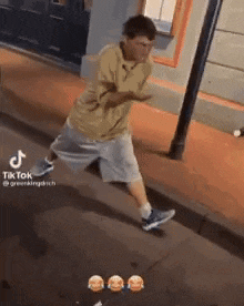 a man is walking down a street with his hands in the air .