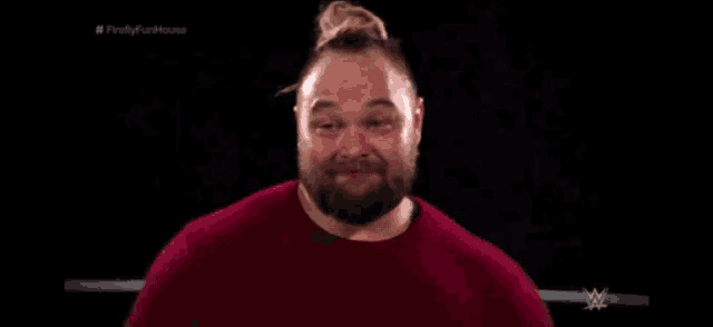 a man with a beard is wearing a red shirt and smiling .