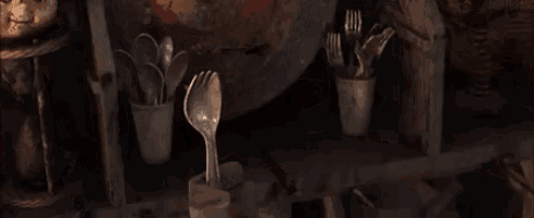 a hammer is sitting on top of a rusty pipe in a room with utensils .