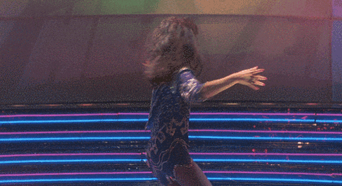 a woman is dancing in front of a neon sign that says ' level ' on it