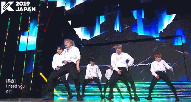 a group of men are dancing on a stage with a sign that says 2019 japan