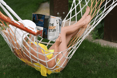 a woman laying in a hammock reading a magazine titled the right stuff