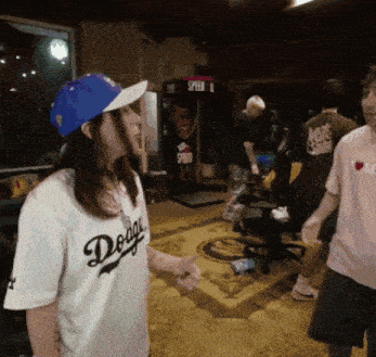 a woman wearing a dodgers jersey stands in a room