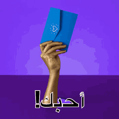 a hand is holding an envelope with a heart on it