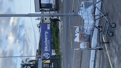 a shopping cart is parked in front of a blueberry sign