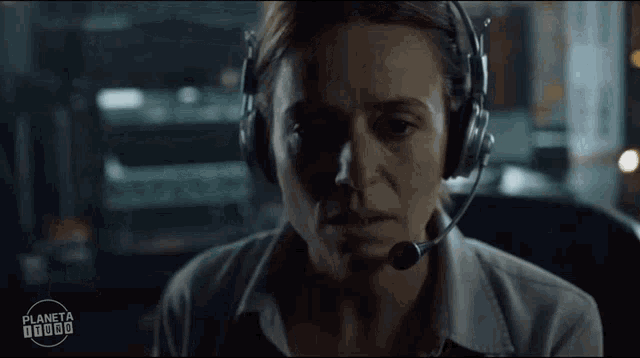 a woman wearing headphones and a microphone is looking at the camera with a planeta 10000 logo in the corner