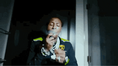 a man is smoking a cigarette in a dark room in a room .