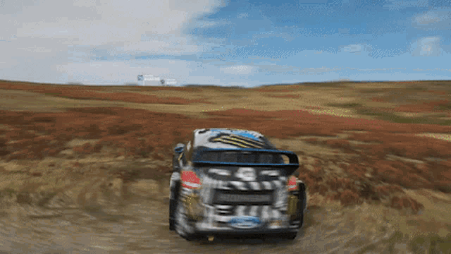 a ford rally car is driving through a field