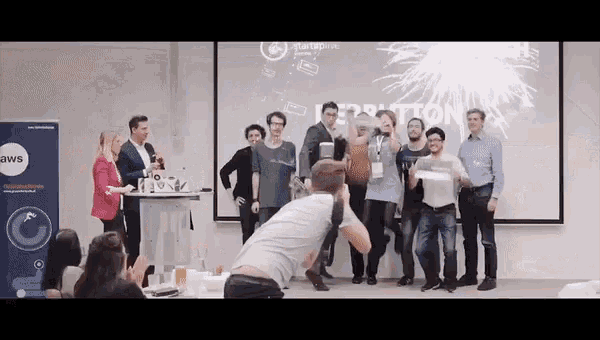 a group of people standing in front of a projector screen that says aws on it