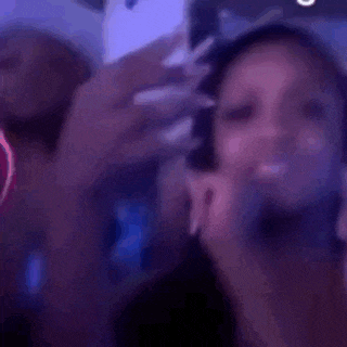 a woman is taking a selfie with her phone in a club .