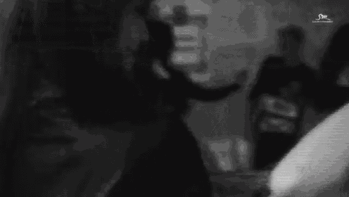 a black and white photo of a woman smiling and looking at the camera .