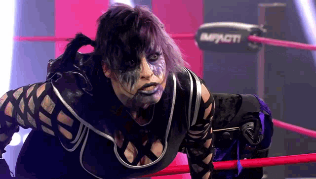a woman in a wrestling ring with the word impacti on the side
