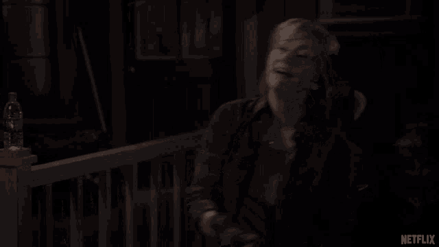 a woman in a plaid shirt is smiling in front of a netflix sign