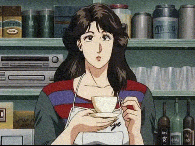 a woman is holding a cup of coffee in front of a shelf with bottles of coffee .