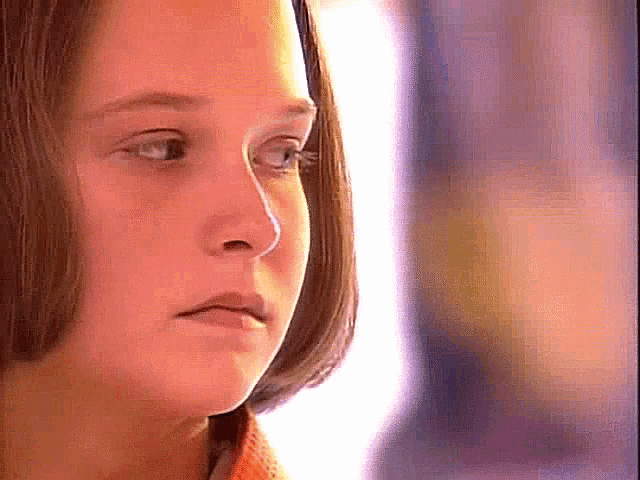 a close up of a young girl 's face with a serious look on her face