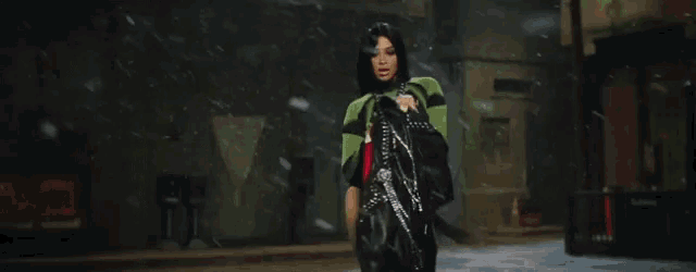 a woman wearing a misbhv sweater and a black skirt