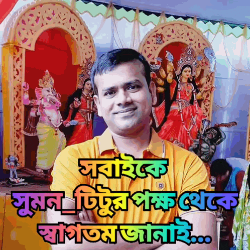 a man in a yellow shirt is standing in front of a statue of a goddess