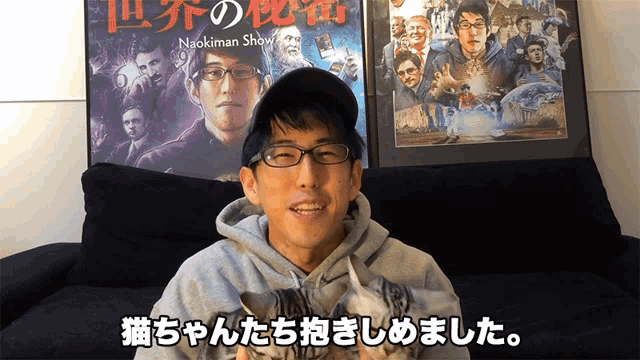 a man holding a kitten in front of a naokiman show movie poster