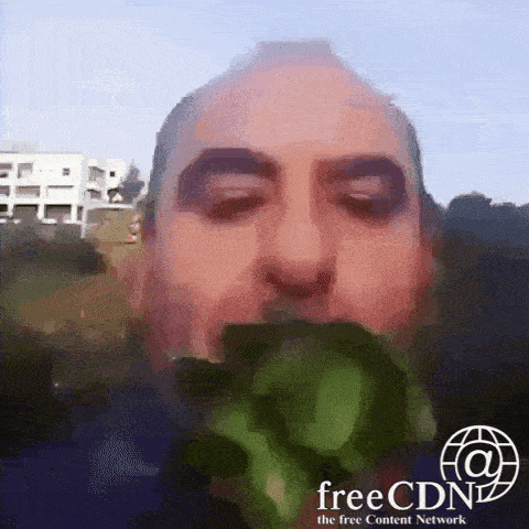 a man is eating a piece of broccoli with the free content network logo behind him