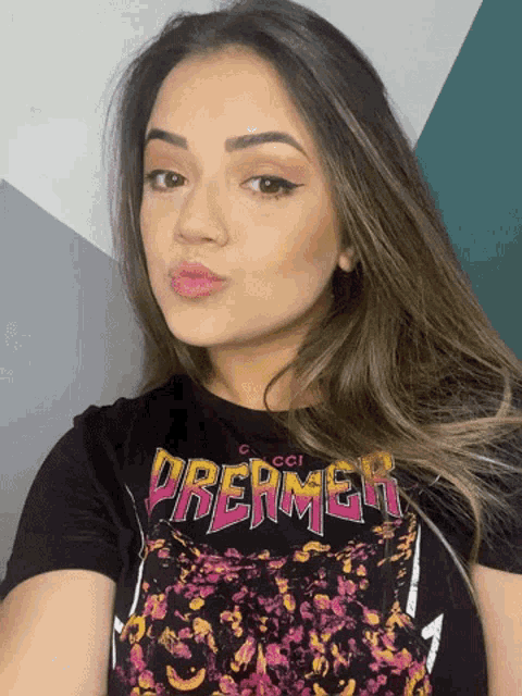 a woman wearing a black t-shirt with the word dreamer on it