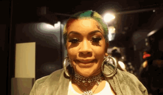 a woman with a tattoo on her forehead has hoop earrings