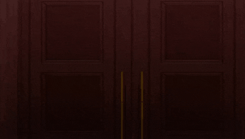 a man in a suit and coat is standing in a doorway