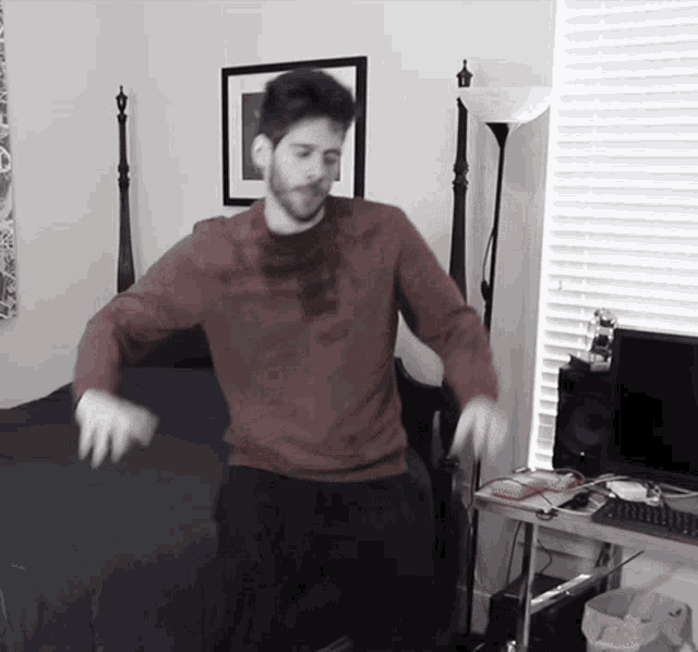 a man in a red shirt is dancing in a room