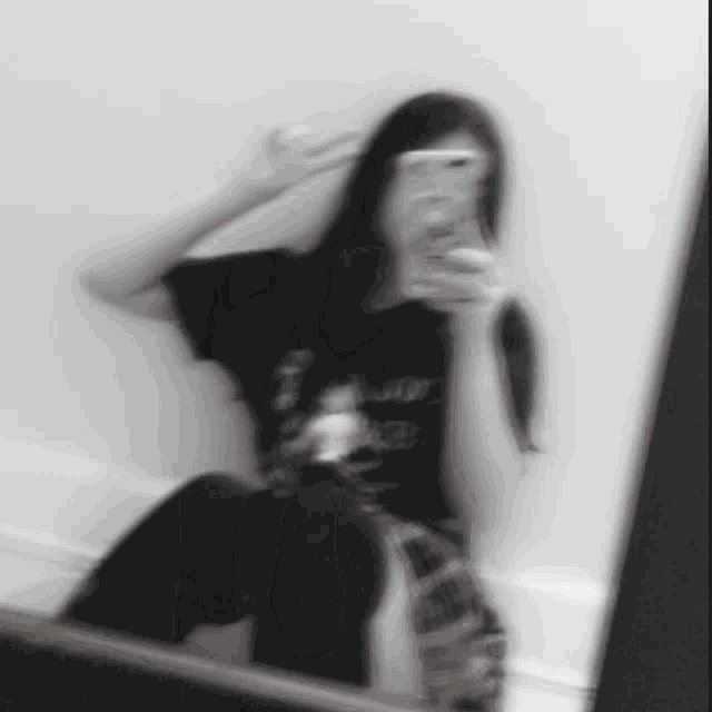 a woman is taking a picture of herself in a mirror .