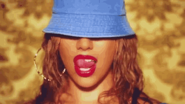 a woman wearing a blue bucket hat with her tongue hanging out