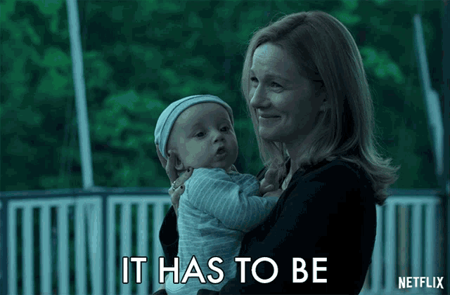 a woman is holding a baby and says it has to be netflix on the bottom