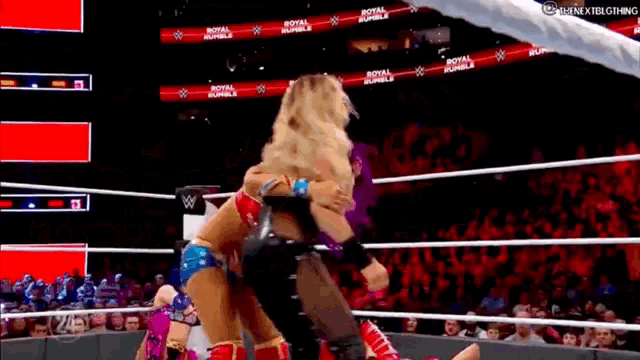 two women are wrestling in a wrestling ring .
