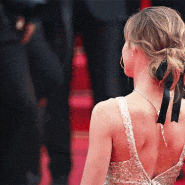 a woman in a sequined dress with a black ribbon in her hair